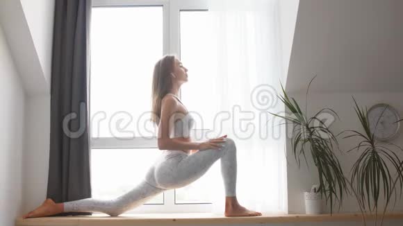 女练战士瑜伽姿势室内靠窗背景视频的预览图