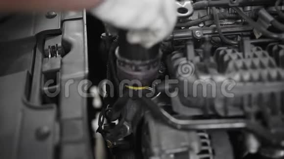 汽车修理工在修理和技术检查过程中在汽车发动机上详细拧盖视频的预览图