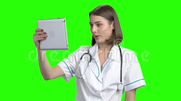 年轻的女医生在平板电脑上上网视频的预览图