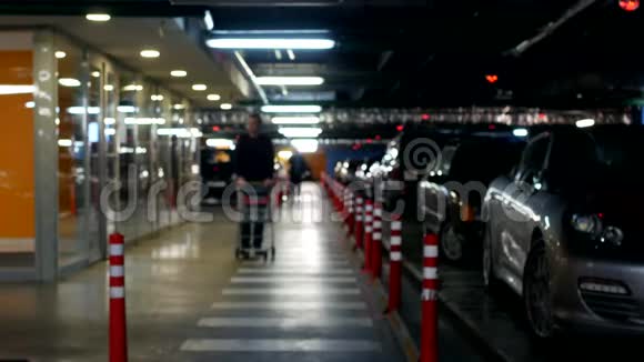 一个带着手推车的年轻人在一个购物中心的地下停车场购物概念视频的预览图
