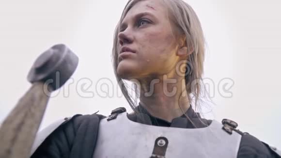 一个穿着中世纪盔甲的悲伤的女人挤压着她的剑和哭泣视频的预览图