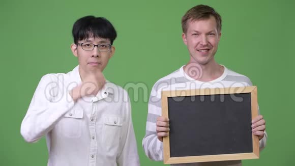 两个快乐的年轻多民族商人展示黑板和竖起大拇指视频的预览图