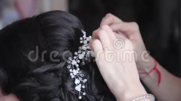 新娘头上戴着一层带有饰物的婚纱特写视频的预览图