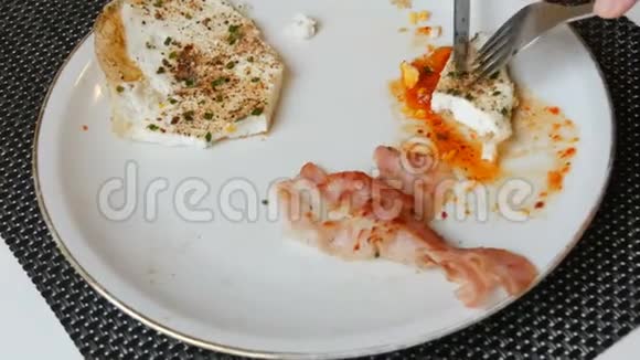 男性贵族用刀叉在白盘上用培根和红酱炒鸡蛋视频的预览图