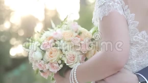 在婚礼那天怀着一束鲜花的爱人新郎拥抱新娘视频的预览图