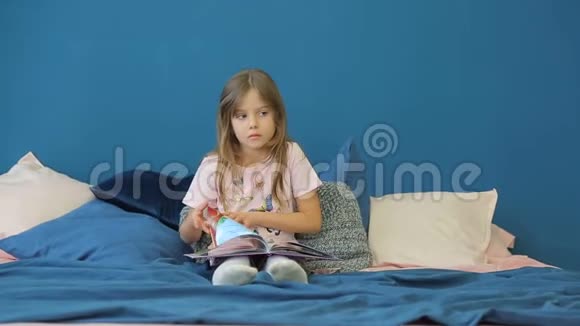 一个小女孩正在床上看书视频的预览图