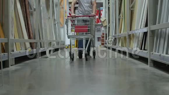 男买家带着购物车走在商店里视频的预览图
