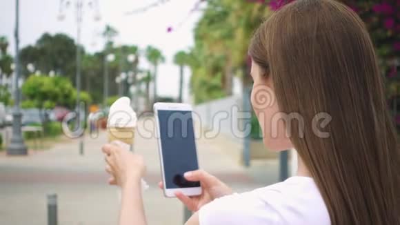 女人拍冰淇淋锥青少年在相机手机上慢镜头拍摄冰淇淋视频的预览图