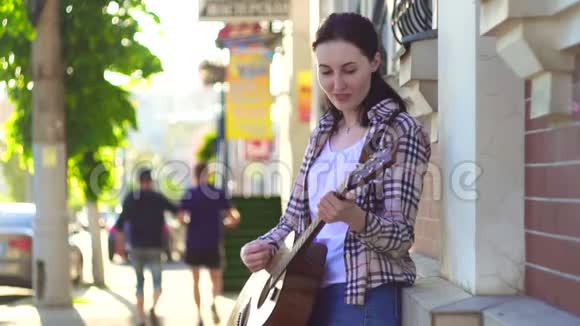 女街头音乐家穿衬衫弹吉他慢舞视频的预览图