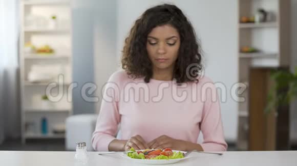 年轻的混血女人在沙拉和食物中加入过多的盐有害的习惯视频的预览图