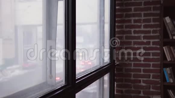 悲伤的女人走到窗前看着城市的街道视频的预览图
