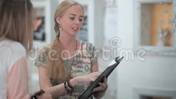漂亮的女咨询师展示了一个目录里面有给年轻女性提供的各种服务视频的预览图