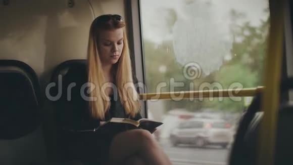 年轻女子在城市公共汽车上开车时看着窗外视频的预览图