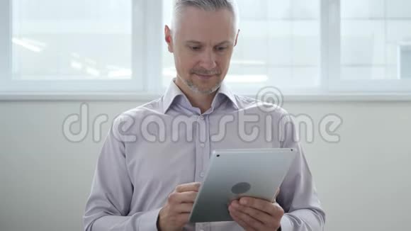 中年男子在使用平板电脑时感到失落视频的预览图