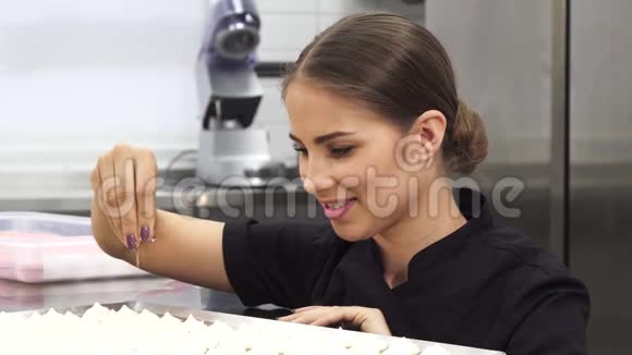 靠近一位漂亮的女糕点厨师用椰子片装饰奶油视频的预览图