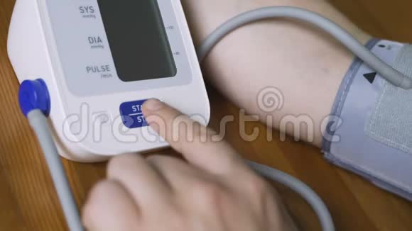 一个男人在家里用血压计测量他的血压光度计显示器和人的手的特写视频的预览图