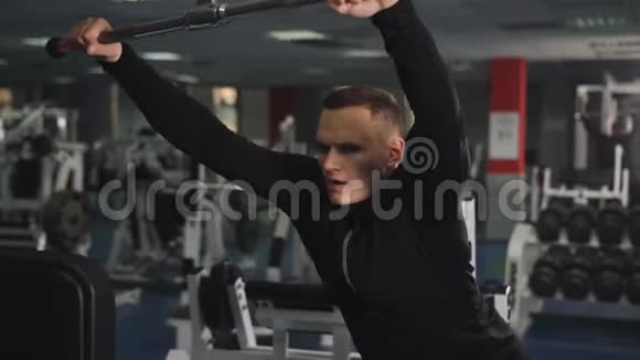 年轻的运动员在健身房为三头肌做下拉运动视频的预览图