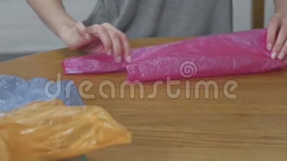 女人小心地折叠塑料袋以供重复使用特写双手视频的预览图