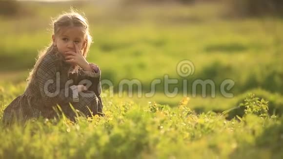 年轻悲伤的女孩孤独在草地上一个年轻的女孩独自坐在草地上沮丧或悲伤视频的预览图