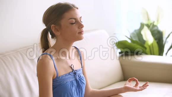 美丽的年轻女子在家打坐呼吸空气练习瑜伽视频的预览图