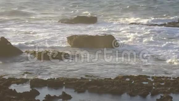 日落时大西洋岩石海岸附近的海浪和低潮埃布视频的预览图
