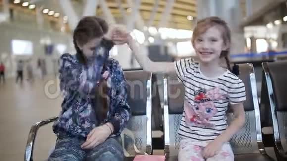 两个带着平板电脑的小妹妹在机场视频的预览图