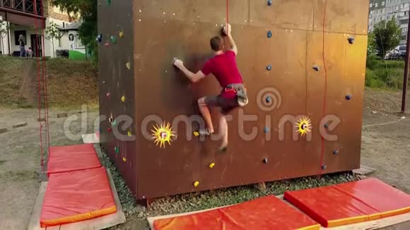 登山者的空中运行速度攀岩轨道上的人造墙户外年轻的快运动员在悬崖上爬视频的预览图