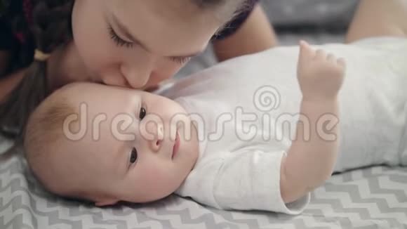 妹亲萌娃弟弟合上女孩可爱的吻婴儿的脸视频的预览图