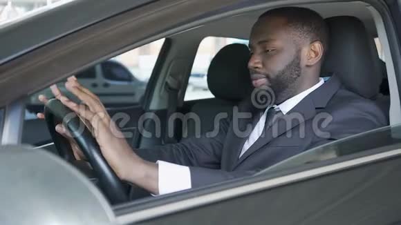 商人坐在车里用手指敲打方向盘焦虑不安视频的预览图