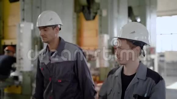 两名工人在生产大厅里拿着大车床视频的预览图