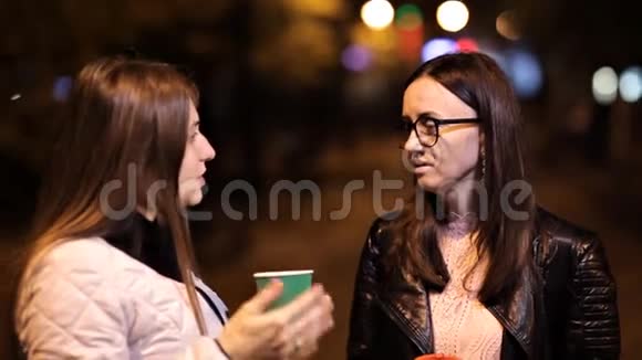两个女孩晚上在城里散步聊天喝咖啡视频的预览图