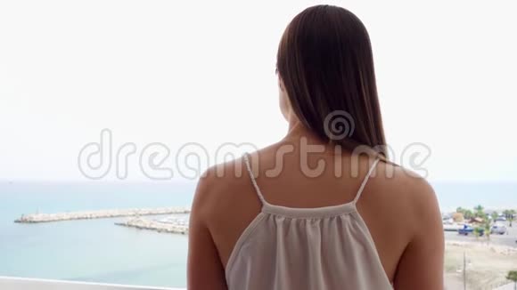 从露台上欣赏海景女性慢动作地走上阳台看着码头视频的预览图