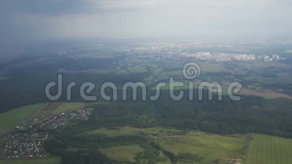 从飞机飞行云层形成的雨落土地上的绿色景观视频的预览图