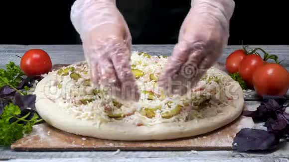 厨师用磨碎的奶酪洒披萨框架专业的比萨饼店厨师戴着手套把最后一层奶酪黑色上视频的预览图