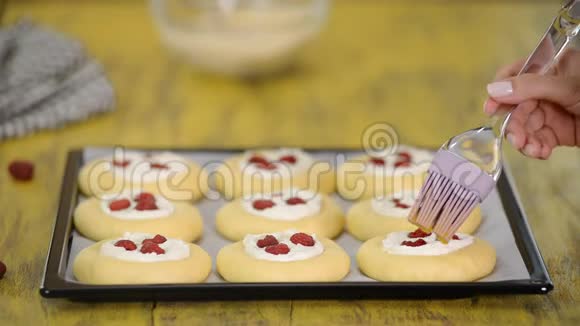 女人在厨房里用干酪覆盆子和什特雷泽莱姆做甜面包自制的概念视频的预览图