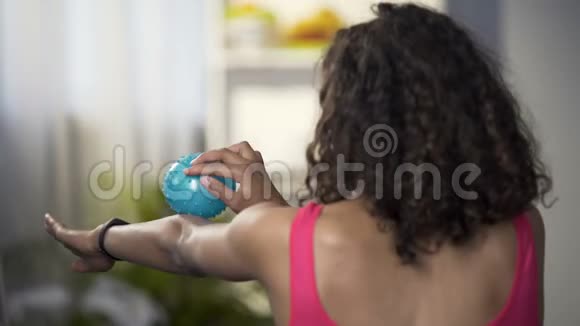 运动的年轻女性用按摩球按摩手臂放松身体肌肉视频的预览图