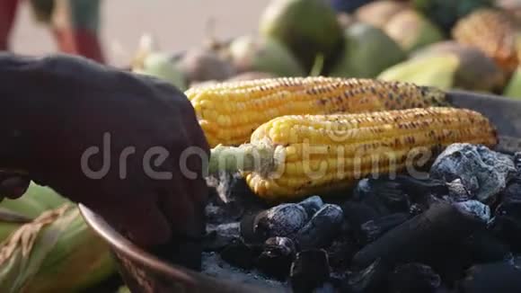 甜玉米棒烤煤和街头小贩转动它视频的预览图