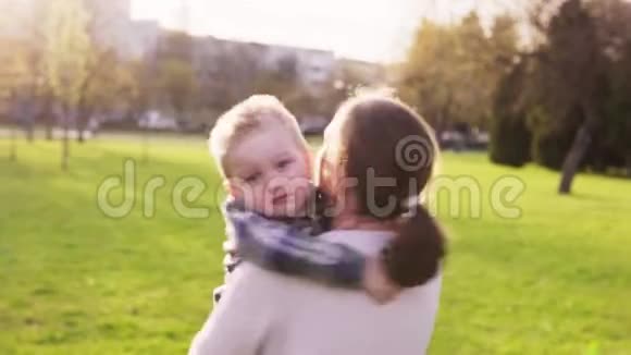 日落时分妈妈和她的小儿子在公园里拥抱和旋转视频的预览图