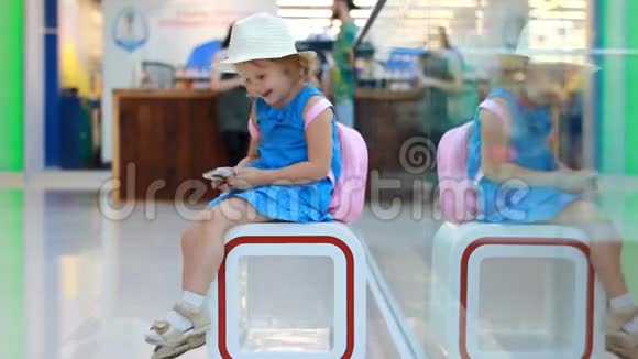 机场候机楼里的女游客玩手机婴儿在智能手机上使用游戏应用程序视频的预览图