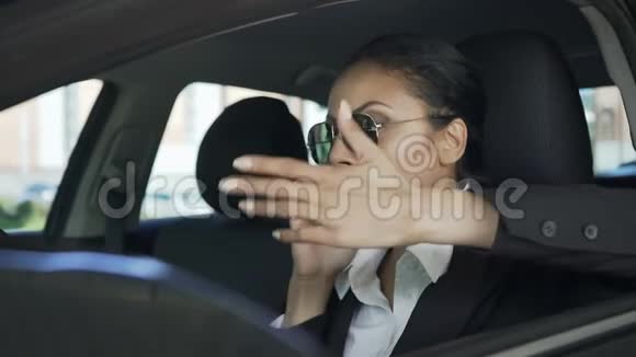 女商人在车上用手机愤怒地打手势失败的交易视频的预览图