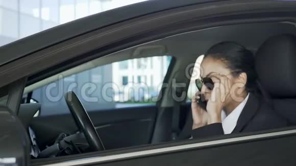 戴墨镜的女士坐在车里用手机说话警察视频的预览图