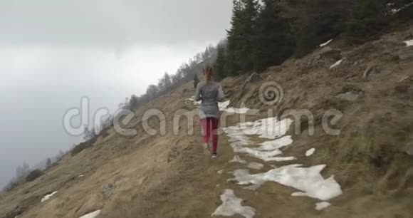 穿过雪道的运动员女孩后面跟着真人女子跑步运动训练秋季或视频的预览图