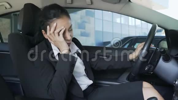 穿西装的混血女人坐在汽车上打方向盘烦恼视频的预览图