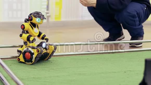 黄色现代机器人在新技术展览会上人控制机器人视频的预览图