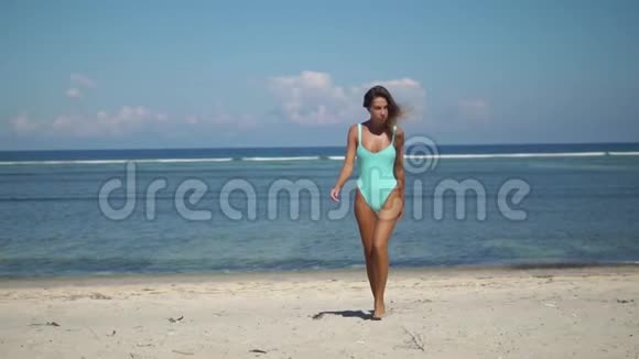 美丽的年轻女子走出大海踏着白色的沙滩视频的预览图
