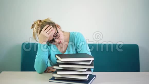 疲倦的女人睡在书和文件上醒来视频的预览图