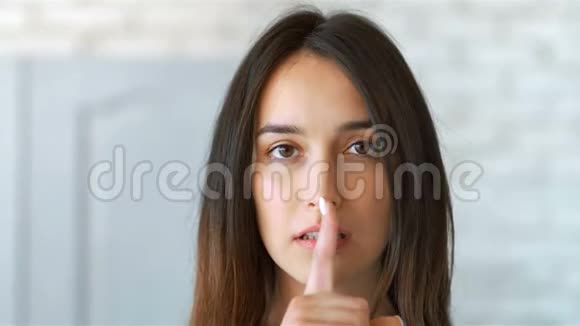 年轻漂亮的女人用手指做着无声的手势视频的预览图