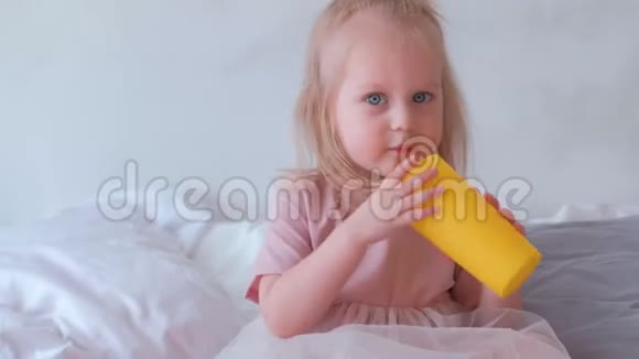 小可爱的金发女孩穿着粉红色的裙子和她妈妈玩黄色的塑料杯视频的预览图