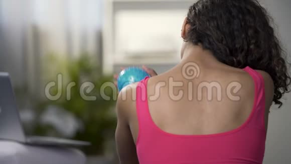 年轻女性用球按摩肩膀锻炼后舒缓肌肉视频的预览图