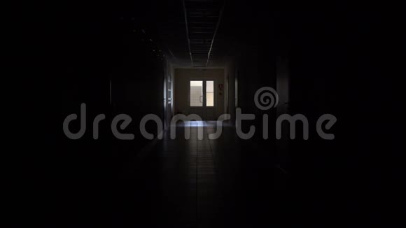 慢动作一个男人的剪影穿过黑暗的走廊开除商人的鬼视频的预览图